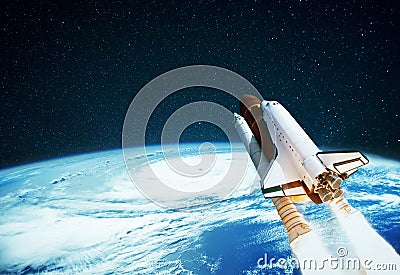 Space rocket launches into space on a background of planet Earth. Spaceship flies in the starry sky with a blue planet. Stock Photo