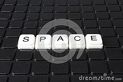 Space title text word crossword. Alphabet letter blocks game texture background. White alphabetical letters on black Stock Photo