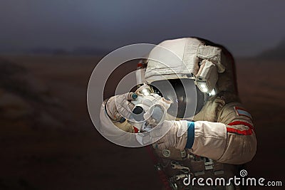 Spaceman with a camera in a space suit on the planet Mars. Stock Photo