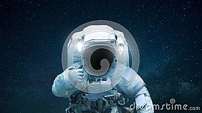 Spaceman in open space with hand shows like. Astronaut travels in space against the background of stars. Stock Photo