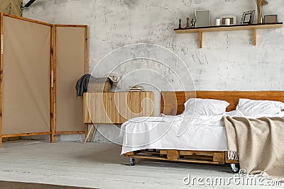 Spacious airy eco style light loft bedroom with a bed and commode Stock Photo