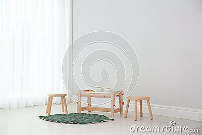 Spacious baby room with wooden furniture near window Stock Photo