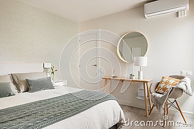 Spacious comfortable bedroom with a double bed, a cosmetic table and a mirror in an eco-boho style interior. The concept Stock Photo