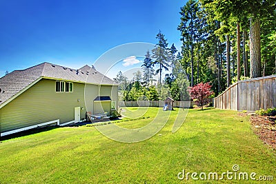 Spacious fenced backyard area with play set for kids. Stock Photo