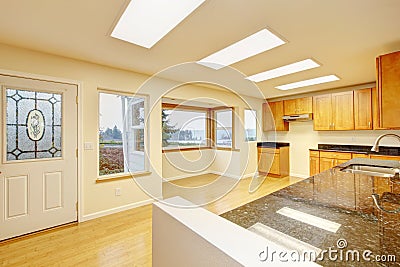 Spacious kitchen room with skylights and black granite tops. Stock Photo