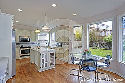 Spacious white kitchen interior with kitchen island. Stock Photo