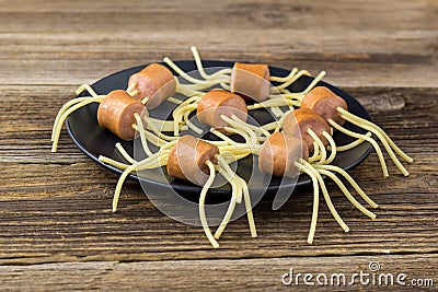 spaghetti with sausages in the form of spiders. Happy kid food for Halloween party Stock Photo