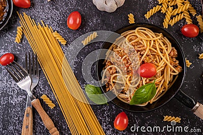 Spaghetti sauteed in a pan-fried with tomatoes and basil Stock Photo