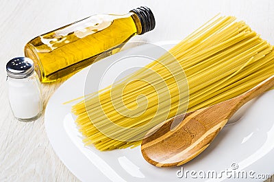 Spaghetti, spoon in dish, salt, vegetable oil in bottle Stock Photo