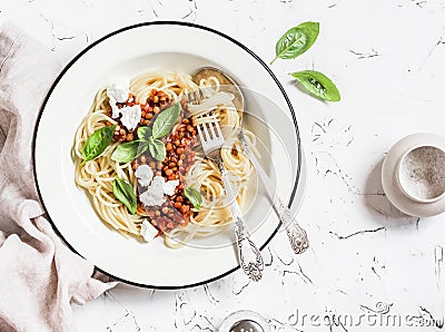 Spaghetti with vegetarian lentil bolognese on a light background. Stock Photo