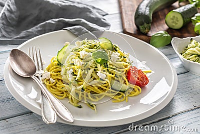 Spaghetti zucchini raw vegan pasta with feta cheese cucumber and basil Stock Photo