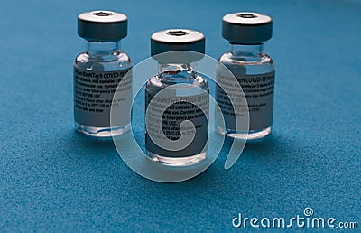 Spain - February 09, 2021 Close up picture of three empty phials of Pfizer COVID19 vaccine with a needle. Selective focus Editorial Stock Photo