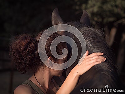 Spain, Horizontal backview of female forming bond with andalusian mare. Stock Photo