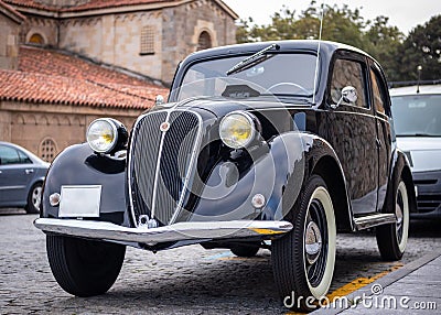 Spain; Sep 2020: Italian classic Fiat 500 Topolino. Iconic vintage black car parked on the street. Yellow round lights, white Editorial Stock Photo