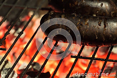 Spanish black pudding on flaming barbecue grill Stock Photo