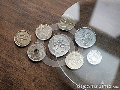 Spanish euro coins under magnifying glass on the wooden background. Local currencies Stock Photo