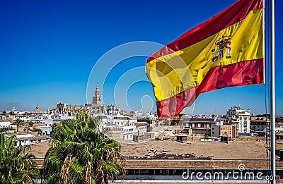 Spanish flag flying with Seville Cathedral in the background in Seville, Spain Editorial Stock Photo