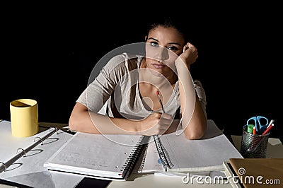 Spanish girl studying tired and bored at home late night looking sad and stressed preparing exam Stock Photo