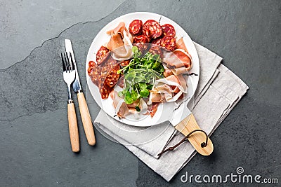 Spanish ham serrano and salami on white marbled plate. Top view. Stock Photo