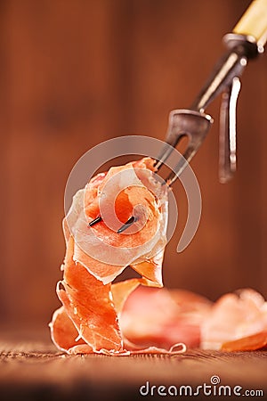 Spanish jamon Cured Meat on large vintage meat fork Stock Photo