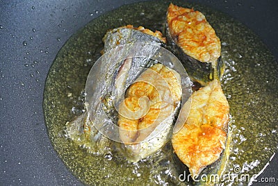 Spanish mackerels fish cut into thick slices and fried using hot cooking oil. Stock Photo