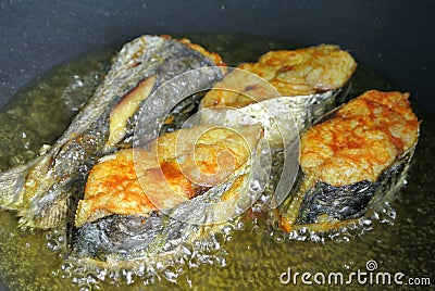Spanish mackerels fish cut into thick slices and fried using hot cooking oil. Stock Photo