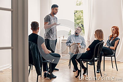 Spanish man talking with rebellious teenagers during meeting of support group Stock Photo