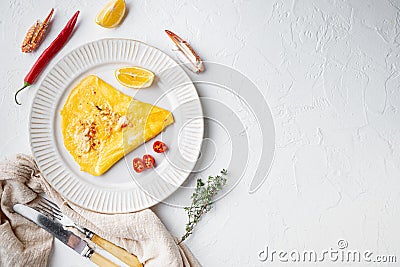 Spanish omelette, fresh red chilli, brown and white crabmeat, lemon, Cheddar cheese, eggs fried, on plate, on white background, Stock Photo