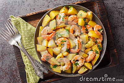 Spanish Potatoes roasted with Garlic Shrimp close-up in a plate. Horizontal top view Stock Photo