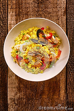 Spanish Seafood Paella in White Bowl on Table Stock Photo