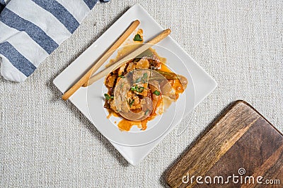 Spanish tapa of fish with orange sauce and bread sticks Stock Photo