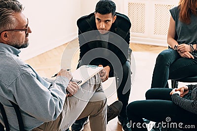 Spanish teenager listening to counselor during meeting of support group Stock Photo