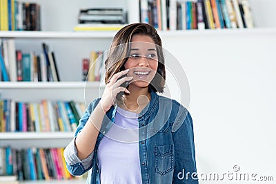 Spanish young adult woman laughing at phone Stock Photo