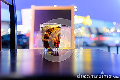 Sparking water soda or cola in the glass on the table with bokeh in the night Stock Photo