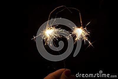 Sparklers in the dark. Sparks with fire in hands on a stick. Awesome Stock Photo