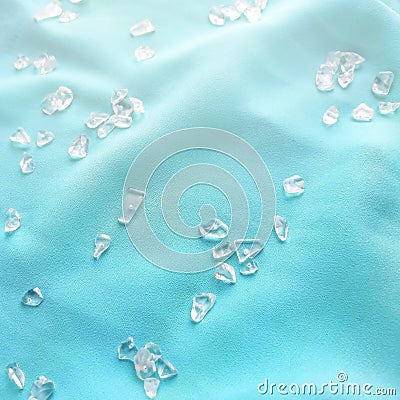 Sparkling glass beads on blue silk background. Stock Photo