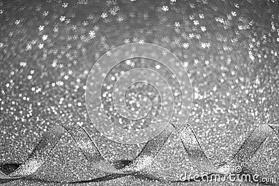 Sparkling gray silver Christmas background - serpentine ribbon with sparkles and bokeh in the form of snowflakes. Stock Photo