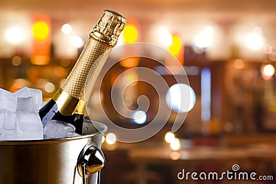 Sparkling wine bottle in ice bucket on blurred restaurant background Stock Photo