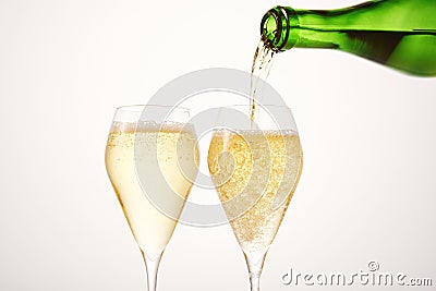 Sparkling wine pours from green bottleneck, creates bubbles. Stock Photo