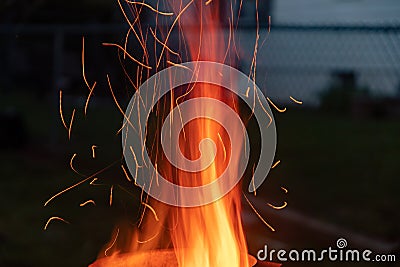 Sparks and flame erupt from the top of a chimney starter fire on a backyard grill Stock Photo