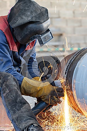 sparks from the Stripping machine in the processing of root weld in welding of pipeline elements Stock Photo