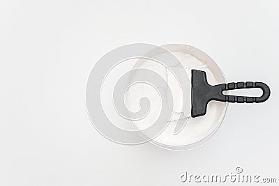 Spatula and a bucket of putty on white wooden boards. Top view Copy space Stock Photo