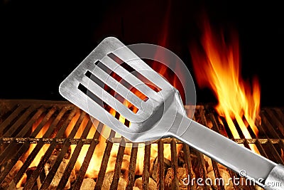 Spatula Close Up And Barbecue Flaming Grill On The Background Stock Photo