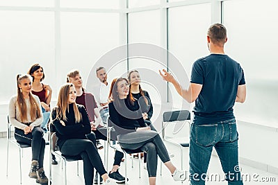 Speaker makes a report for a group of diverse young people. Stock Photo