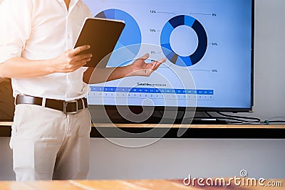 Speaker man talking to audience giving a lecture and holding tablet. Business presentation concept Stock Photo