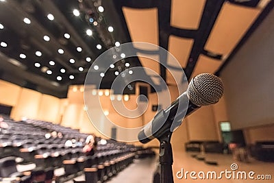 Speaker`s microphone blurred in blurry auditorium music concert hall background or seminar meeting room in educational business Stock Photo
