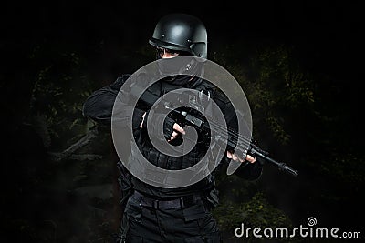 Spec ops police officer SWAT in black uniform studio Stock Photo