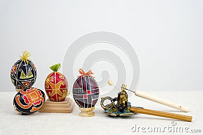 special devices for coloring eggs four eggs of different colors red yellow black with tufts of thread on a white Stock Photo