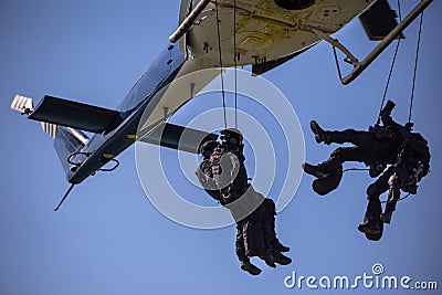 Special forces team helicopter rope jump Stock Photo