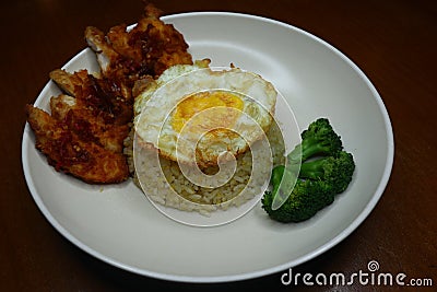 Special fried rice with spicy chili fried chicken sauce, broccoli and fried omelet Stock Photo